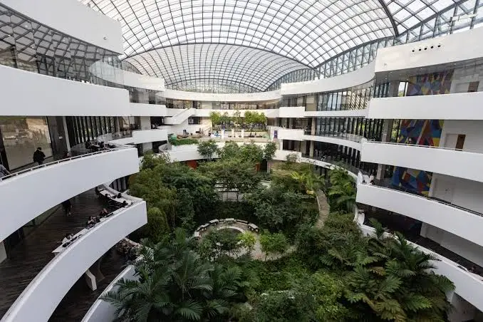 Vão interno de um shopping com jardim cercado por andares