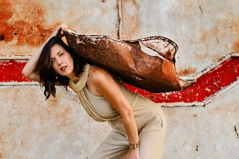 Joana Duah posando com uma mochila diante de uma parede pintada