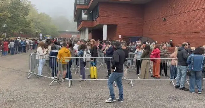 Fila de eleitores cercada por grades diante de um prédio em Londres