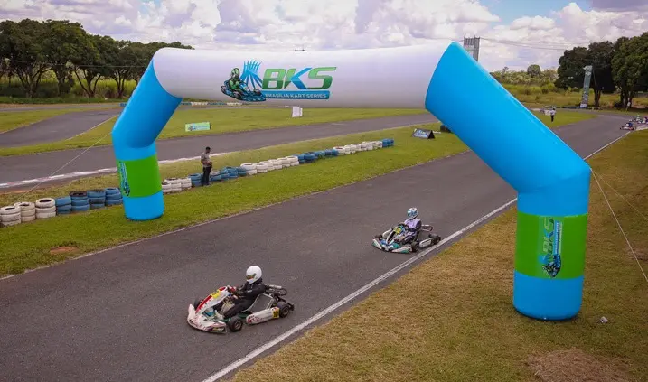 Karts correndo em uma pista com arco inflável da Brasília Kart Series