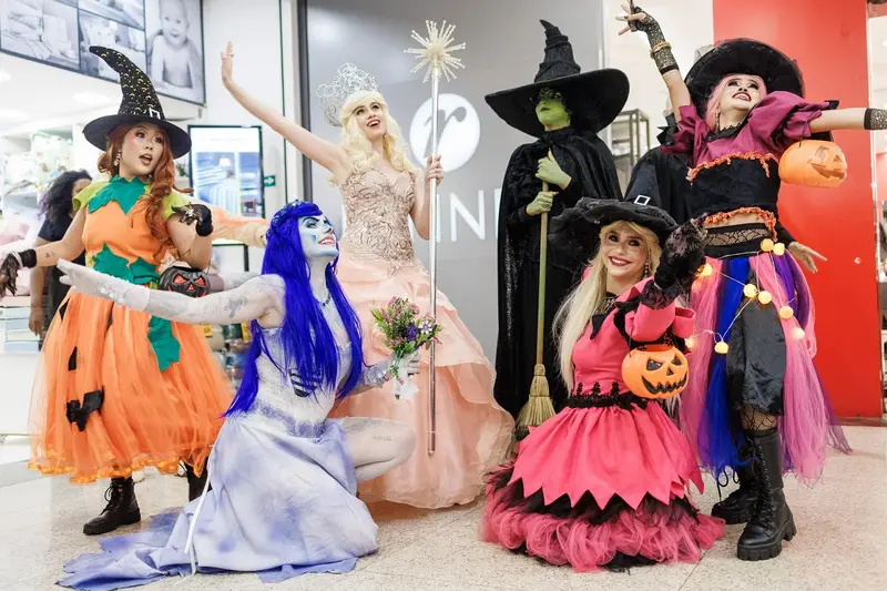 Personagens fantasiadas de bruxas e figuras de Halloween em um shopping