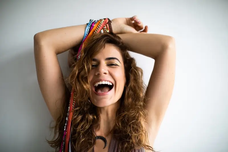 Mariana Aydar sorrindo com os braços sobre a cabeça
