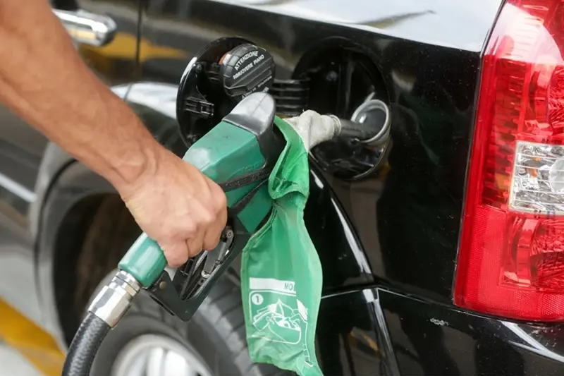 Mão abastecendo um carro na bomba de combustível