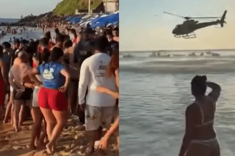 Banhistas na areia e helicóptero de resgate sobre o mar