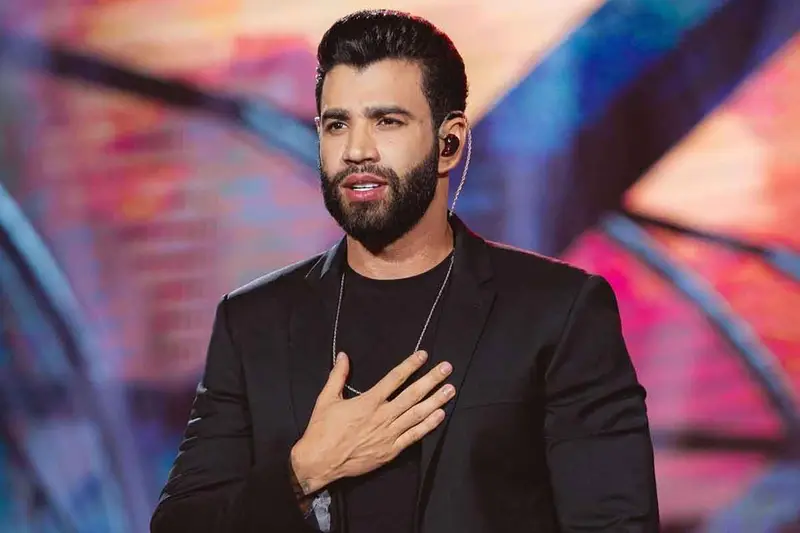 Cantor de barba com a mão no peito em um show