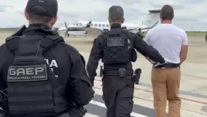 Agentes da Polícia Penal Federal escoltando um homem até um avião